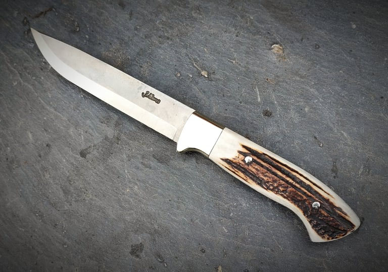 Jagdmesser mit Hirschhorngriff auf Schiefer