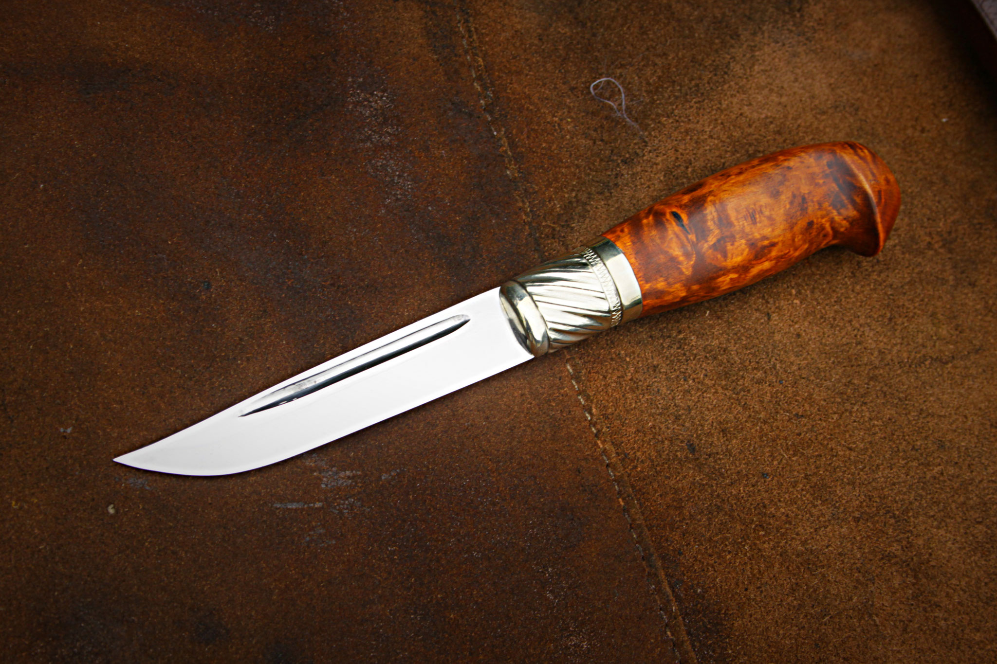 Puukko in schwarzer Lederscheide auf Schiefer