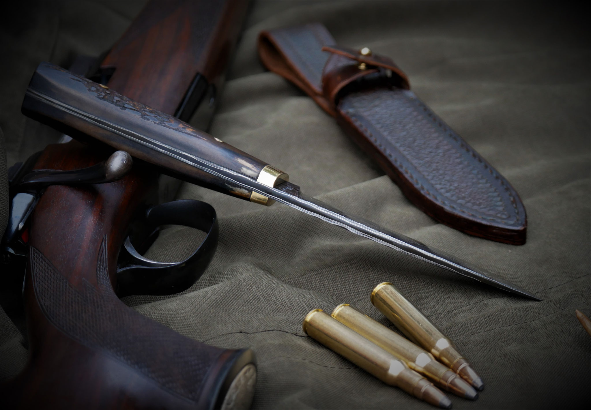 Schmales Jagdmesser mit Gewehr und Munition